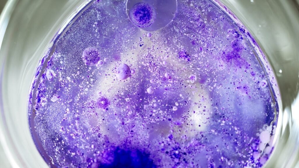 pexels photo 20105299 Close-up of a vibrant purple chemical reaction in a petri dish, displaying bubbles and intricate textures.