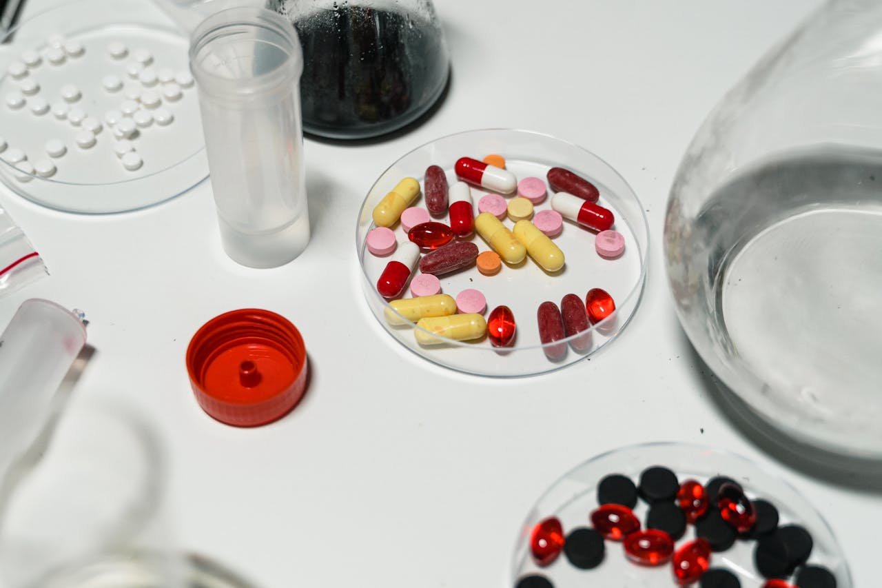 why-choose-us Assorted pills and capsules arranged on a lab table, emphasizing pharmacology and medicine.